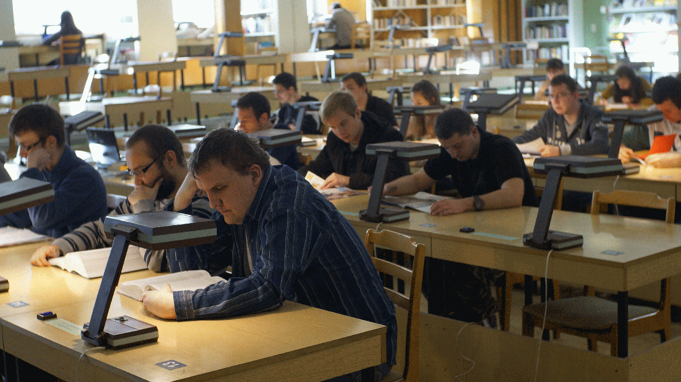 Studenci czytający książki w bibliotece Studenci czytający książki w bibliotece